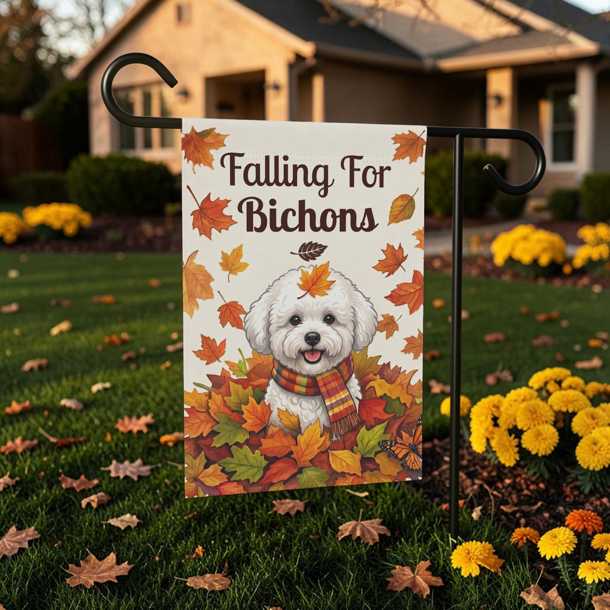 Falling For Bichons garden flag on a black stand on a leaf-scattered front lawn, showing a Bichon Frise in a scarf among fall foliage and a monarch butterfly
