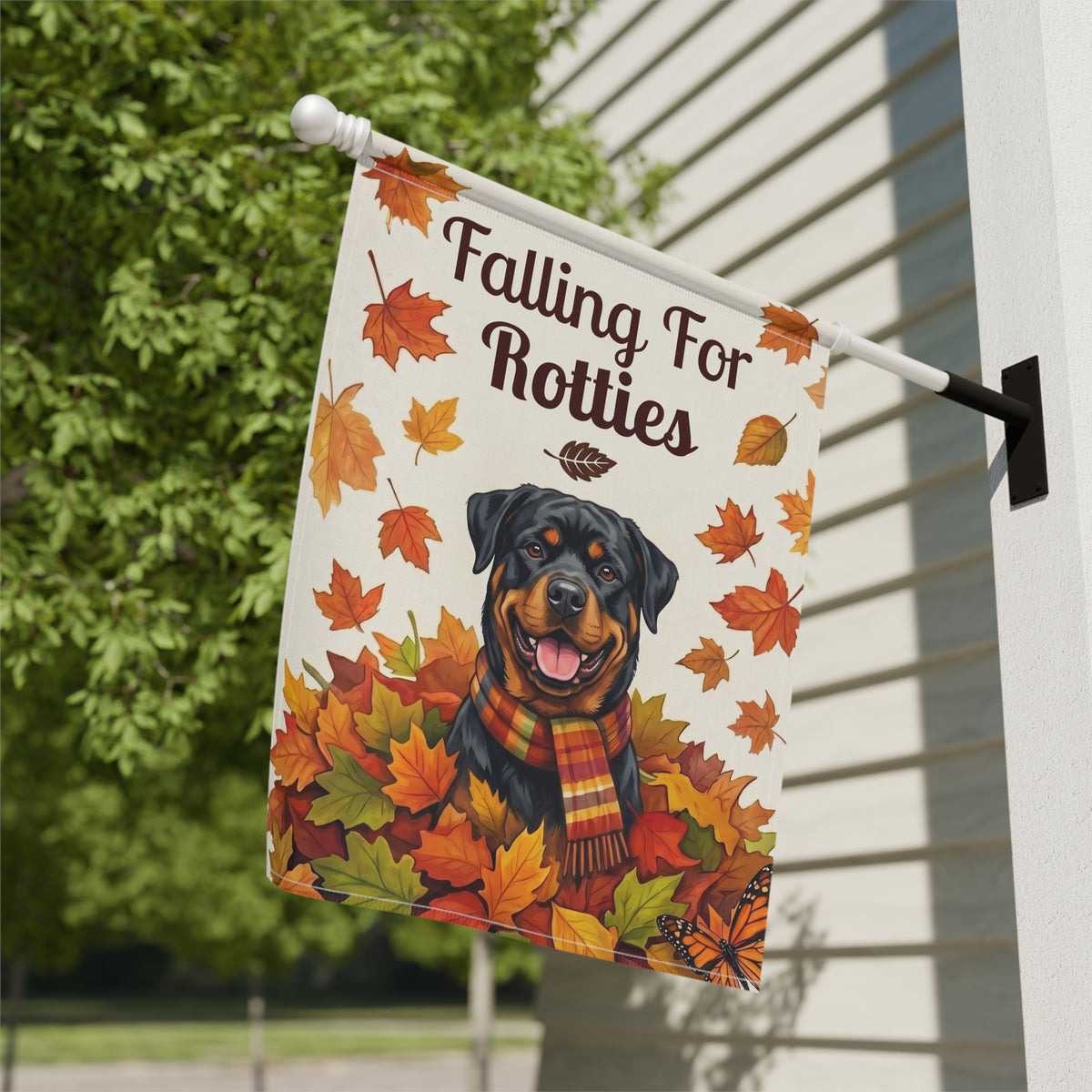 Close-up of the Falling For Rotties Rottweiler garden flag mounted on a white wall-bracket flagpole showing fabric and stitching detail