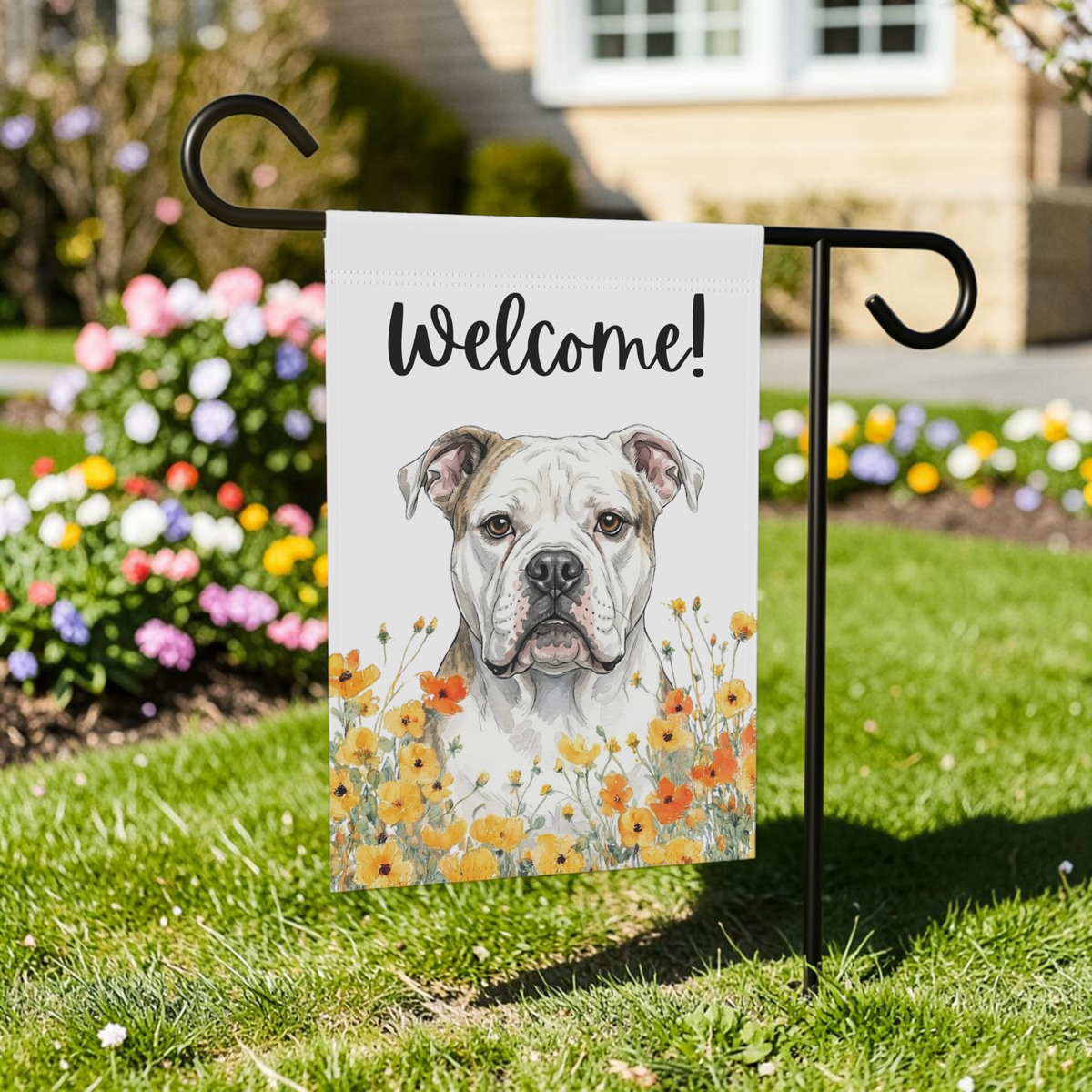 Yellow Poppies American Bulldog Welcome garden flag on a black stand in a front yard with a colorful flower bed and green lawn