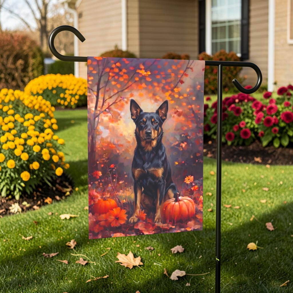 Fall Australian Kelpie With Pumpkins on a garden flag stand in front of a house with autumn landscaping