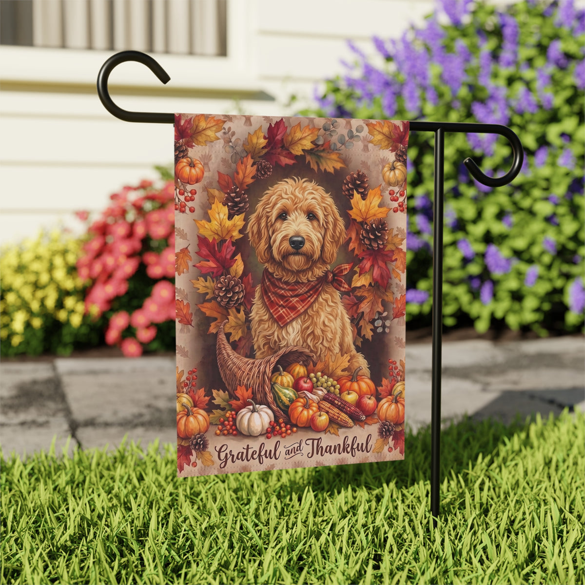 Grateful and Thankful Doodle Golden Noodle Thanksgiving garden flag shown on a stand near a walkway with potted mums